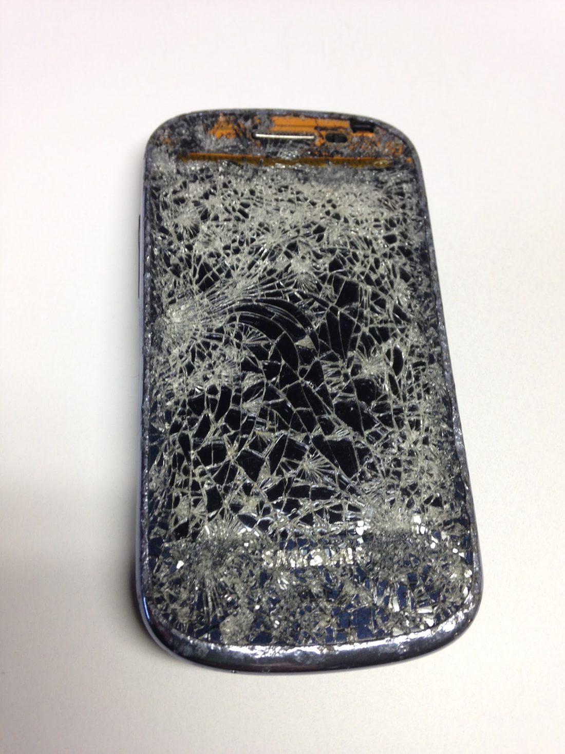 A Samsung phone with a completely shattered screen brought in for repair at iCompute in Coos Bay, Oregon